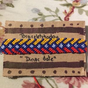 A arrow styled bracelet made of cotton thread.